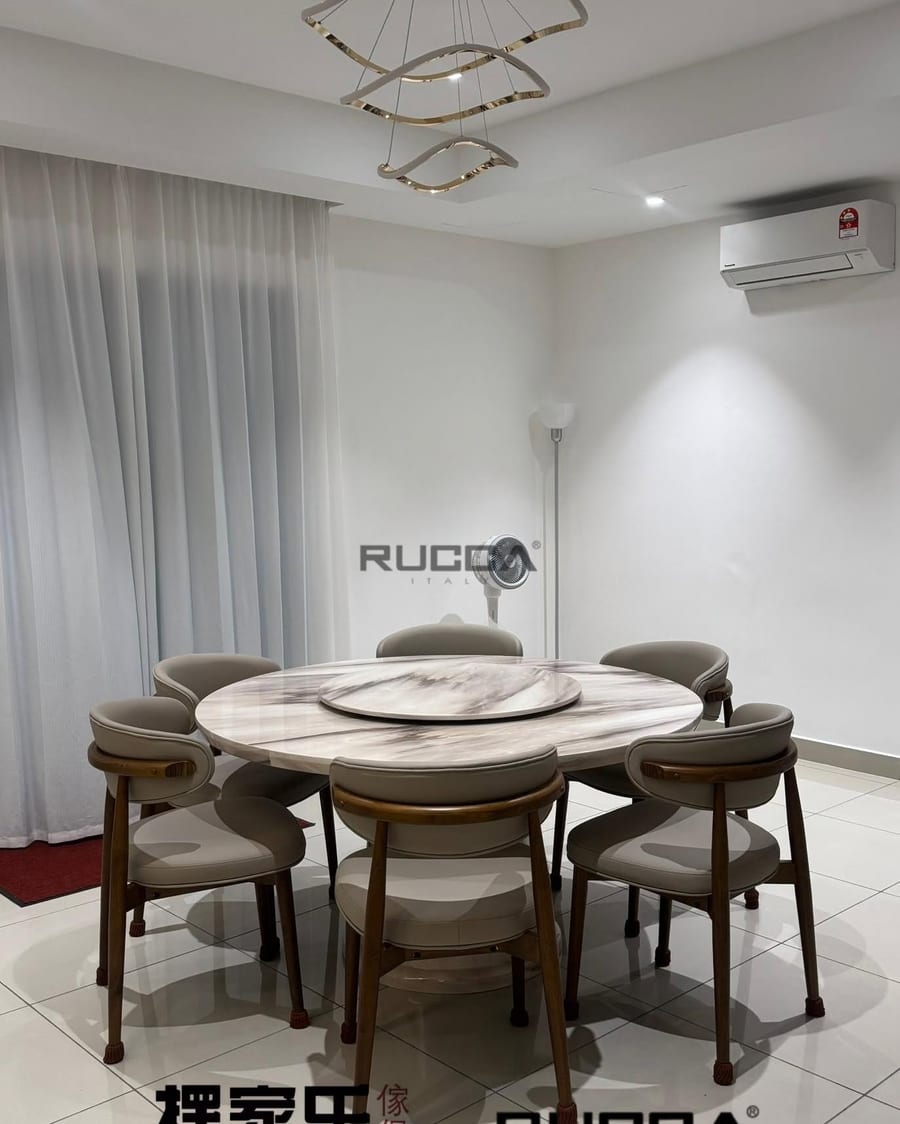 A round dining table and upholstered chairs beneath a ring pendant light.